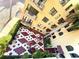 Top-down view of a charming courtyard with red and white patterned tile surrounded by lush greenery and the building's facade at 130 4Th N Ave # 315, St Petersburg, FL 33701