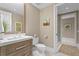 Neutral-toned bathroom featuring a sleek vanity, toilet, decorative mirror, and glass-enclosed shower at 146 4Th Ne Ave # 600, St Petersburg, FL 33701