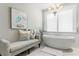 Elegant bathroom with a freestanding tub, chandelier, framed art and plantation shutters for natural light at 146 4Th Ne Ave # 600, St Petersburg, FL 33701