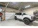 Spacious garage with epoxy flooring, storage shelving, and a new white 2023 Ford Bronco parked inside at 146 4Th Ne Ave # 600, St Petersburg, FL 33701