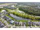 Aerial view showcasing homes along a pond, manicured lawns, and the street layout in this waterfront community at 19432 Whispering Brook Dr, Tampa, FL 33647