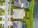 Aerial view of a home's roof, backyard with a pool, green lawn, and proximity to community sidewalks and a pond at 19432 Whispering Brook Dr, Tampa, FL 33647