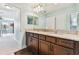 Bright bathroom with a double vanity, granite countertops, and dark wood cabinetry at 19432 Whispering Brook Dr, Tampa, FL 33647