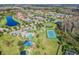Aerial view featuring a tennis court, pool, clubhouse, parking, and playground within a lush, green community at 19432 Whispering Brook Dr, Tampa, FL 33647