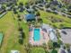Aerial view highlighting a community pool with ample seating, a clubhouse, and a playground at 19432 Whispering Brook Dr, Tampa, FL 33647