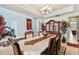 Formal dining room with elegant chandelier, decorative cabinet, and seating for six, all with ornate accents at 19432 Whispering Brook Dr, Tampa, FL 33647