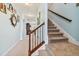 Hallway leading to carpeted stairs, decorated with art and featuring a clock, with a view into the living area at 19432 Whispering Brook Dr, Tampa, FL 33647