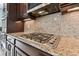 Modern kitchen with granite countertops, stainless steel appliances, dark wood cabinets and tiled backsplash at 19432 Whispering Brook Dr, Tampa, FL 33647