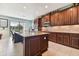 Spacious kitchen featuring dark wood cabinetry, stainless steel appliances, a center island, and a lake view at 19432 Whispering Brook Dr, Tampa, FL 33647