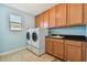 Laundry room features a full washer and dryer set, a sink, and wooden cabinets for storage at 19432 Whispering Brook Dr, Tampa, FL 33647