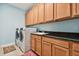 Bright laundry room featuring a granite countertop, cabinets, and a modern washer and dryer at 19432 Whispering Brook Dr, Tampa, FL 33647