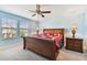 Bright main bedroom features a wooden sleigh bed, bedside tables with lamps, and a ceiling fan at 19432 Whispering Brook Dr, Tampa, FL 33647