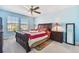 Bright main bedroom boasts a ceiling fan, and two windows with a luxurious bed and bedside tables at 19432 Whispering Brook Dr, Tampa, FL 33647