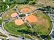 Aerial view of multiple well-maintained baseball fields with green grass and orange clay at 22647 Eagles Watch Dr, Land O Lakes, FL 34639