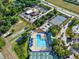Aerial view of community amenities including pool, tennis courts, commercial building and wooded areas at 22647 Eagles Watch Dr, Land O Lakes, FL 34639