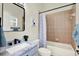 Cozy bathroom featuring neutral tile, a tub with shower, a modern vanity, and stylish decor at 22647 Eagles Watch Dr, Land O Lakes, FL 34639