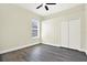 Bedroom features dark wood-look floors, neutral walls, a ceiling fan, and double door closet at 22647 Eagles Watch Dr, Land O Lakes, FL 34639