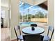 Breakfast nook with view of a screened in pool area, palm trees and blue skies at 22647 Eagles Watch Dr, Land O Lakes, FL 34639