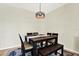 A dining room area with a wooden table, six chairs, a bench, and a striking modern chandelier at 22647 Eagles Watch Dr, Land O Lakes, FL 34639