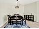 A dining room featuring a wooden table with chairs, a modern light fixture, and a decorative blue rug at 22647 Eagles Watch Dr, Land O Lakes, FL 34639