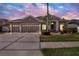 Charming home featuring a three car garage, well-manicured lawn, and inviting landscaping at 22647 Eagles Watch Dr, Land O Lakes, FL 34639