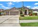 Charming home featuring a three car garage, well-manicured lawn, and inviting landscaping at 22647 Eagles Watch Dr, Land O Lakes, FL 34639