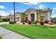 Charming home featuring a manicured lawn, complemented by mature landscaping and a three-car garage at 22647 Eagles Watch Dr, Land O Lakes, FL 34639