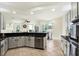The kitchen area features white cabinets, dark countertops and a view to the dining area and pool at 22647 Eagles Watch Dr, Land O Lakes, FL 34639