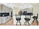 Kitchen features gray cabinets, black countertops, stainless steel appliances, and bar stool seating at 22647 Eagles Watch Dr, Land O Lakes, FL 34639