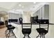 Modern kitchen with gray cabinets, black countertops, stainless steel appliances, and bar stool seating at 22647 Eagles Watch Dr, Land O Lakes, FL 34639