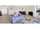 Comfortable living room featuring a blue sofa, neutral walls, and tile flooring at 22647 Eagles Watch Dr, Land O Lakes, FL 34639