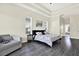 Bright main bedroom featuring tray ceilings, hardwood floors, and seating at 22647 Eagles Watch Dr, Land O Lakes, FL 34639