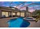 A screened-in pool and spa under twilight offer a relaxing backyard escape at 22647 Eagles Watch Dr, Land O Lakes, FL 34639