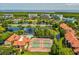 Expansive aerial view of a coastal community featuring swimming pools, tennis courts, water features, and lush landscapes at 2400 Feather Sound Dr # 1118, Clearwater, FL 33762