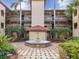 Charming courtyard featuring a fountain, lush landscaping, and residential buildings with balconies, creating inviting outdoors at 2400 Feather Sound Dr # 1118, Clearwater, FL 33762