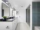 Spacious bathroom featuring double sinks, updated lighting, and a glass-enclosed shower at 2523 Northfield Ln, Clearwater, FL 33761