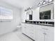 Modern bathroom featuring double sinks, white cabinetry, and contemporary lighting at 2523 Northfield Ln, Clearwater, FL 33761