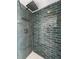 Close-up of updated shower with blue accent tile, rainfall shower head, and modern fixtures at 2523 Northfield Ln, Clearwater, FL 33761