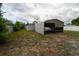 View of the backyard with metal car port, shed, and fencing at 2610 E Yukon St, Tampa, FL 33604