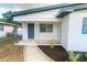 Inviting front porch featuring a stylish blue door, tiled flooring, and decorative metal railings at 2610 E Yukon St, Tampa, FL 33604