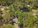 Stunning aerial view of a home surrounded by lush trees and a serene pond at 26290 Hayman Rd, Brooksville, FL 34602