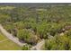 Aerial view of the heavily wooded property featuring a pond and road frontage at 26290 Hayman Rd, Brooksville, FL 34602