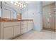 Well-lit bathroom featuring a double vanity, tile flooring, and a walk-in shower with tile surround at 26290 Hayman Rd, Brooksville, FL 34602