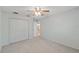 Bedroom featuring plush carpet, ceiling fan, large closet, and neutral walls at 26290 Hayman Rd, Brooksville, FL 34602