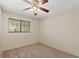 Cozy bedroom featuring neutral carpet, ceiling fan, a large window, and a serene atmosphere at 26290 Hayman Rd, Brooksville, FL 34602