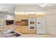Well-lit kitchen with natural cabinets, double oven, and breakfast bar to the living area at 26290 Hayman Rd, Brooksville, FL 34602