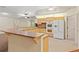 Kitchen with wood cabinetry, breakfast bar, and white appliances open to living area at 26290 Hayman Rd, Brooksville, FL 34602