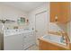 Functional laundry room equipped with a sink, washer, dryer, and storage at 26290 Hayman Rd, Brooksville, FL 34602