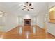 Cozy living room featuring a classic fireplace, hardwood flooring, and natural light from surrounding windows at 26290 Hayman Rd, Brooksville, FL 34602