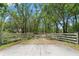 Gated driveway leading to a secluded property surrounded by mature trees providing privacy at 26290 Hayman Rd, Brooksville, FL 34602